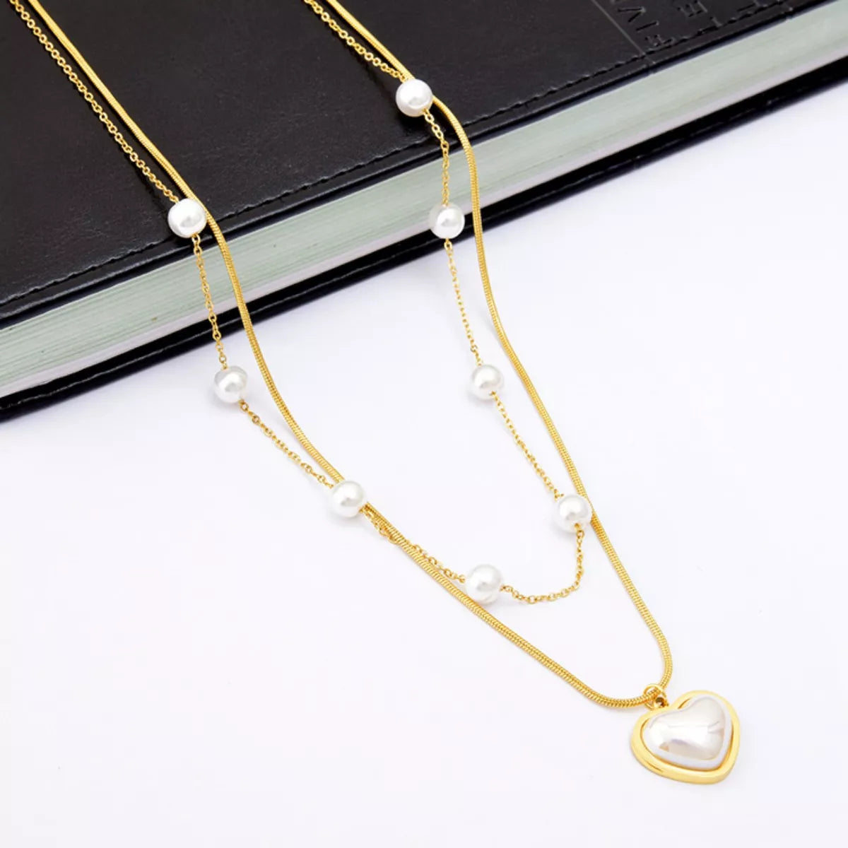 Elegant 18K gold-plated double layered heart necklace featuring synthetic pearls and a heart pendant for timeless luxury styling.