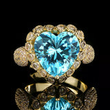 18K gold-plated heart-shaped ring featuring a brilliant aquamarine-colored center stone surrounded by sparkling zircon accents.