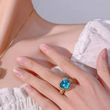 18K gold-plated heart-shaped ring featuring a brilliant aquamarine-colored center stone surrounded by sparkling zircon accents.
