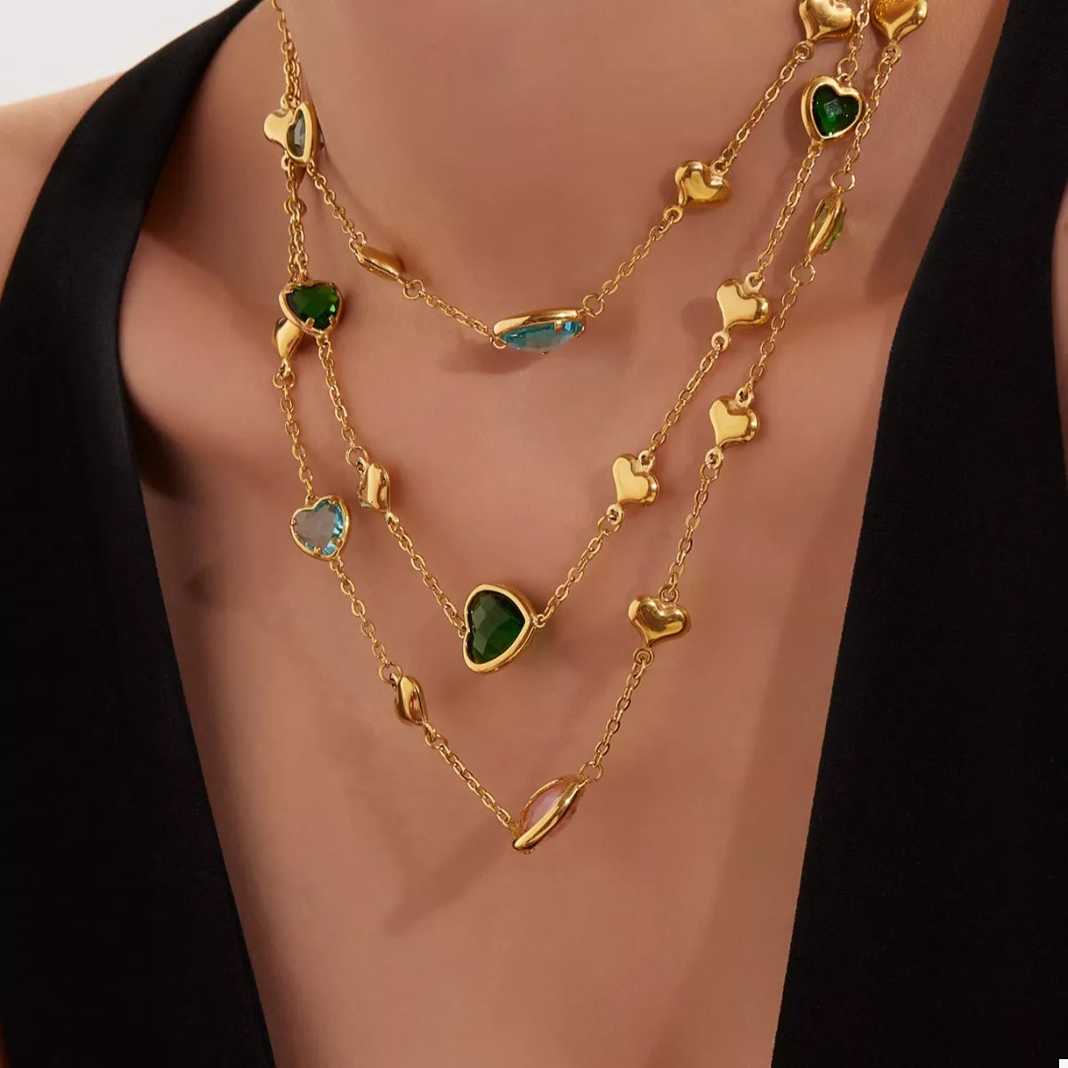 18K gold-plated heart necklace featuring a heart-shaped glass stone available in dark green, light blue, and blush pink with delicate gold heart accents.