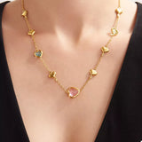 18K gold-plated heart necklace featuring a heart-shaped glass stone available in dark green, light blue, and blush pink with delicate gold heart accents.