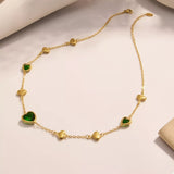 18K gold-plated heart necklace featuring a heart-shaped glass stone available in dark green, light blue, and blush pink with delicate gold heart accents.