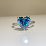 925 sterling silver ring featuring a large sparkling blue heart-shaped zircon stone in a prong setting with small clear accents along the silver band.