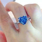 925 sterling silver ring featuring a large sparkling blue heart-shaped zircon stone in a prong setting with small clear accents along the silver band.