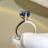 925 sterling silver ring featuring a large sparkling blue heart-shaped zircon stone in a prong setting with small clear accents along the silver band.