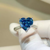 925 sterling silver ring featuring a large sparkling blue heart-shaped zircon stone in a prong setting with small clear accents along the silver band.