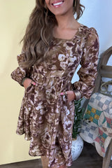 Woman wearing an abstract floral print square neck long sleeve mini shift dress in warm brown tones with a relaxed fit, perfect for fall styling.