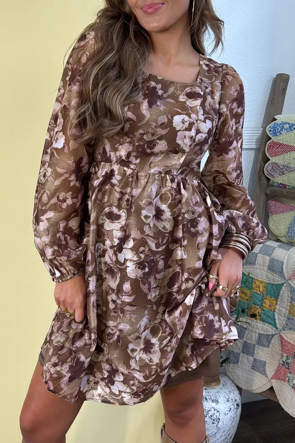 Woman wearing an abstract floral print square neck long sleeve mini shift dress in warm brown tones with a relaxed fit, perfect for fall styling.