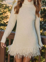Woman wearing a apricot fringe turtleneck long sleeve sweater dress with brown knee-high boots, a cozy fall outfit from Chic Mystik Boutique.