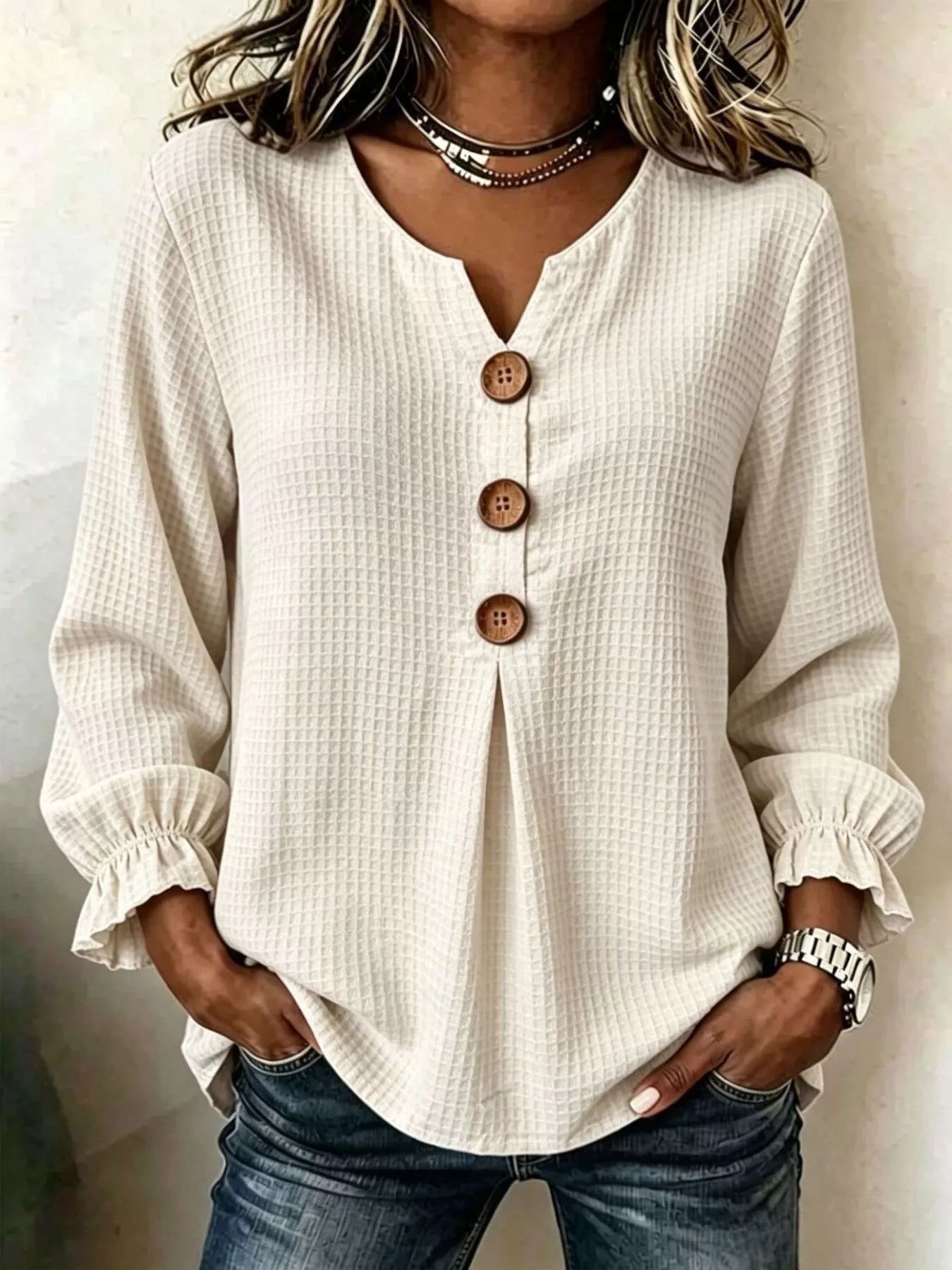 Women’s apricot waffle knit flounce sleeve top with button front detail and ruffled cuffs.