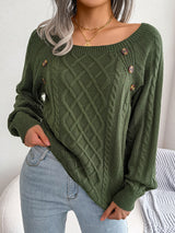 Woman wearing an army green cable-knit sweater with decorative buttons, paired with light-wash jeans, layered gold necklaces, and a white handbag. Perfect for cozy fall and winter outfits.