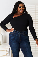Woman wearing a black Basic Bae asymmetrical neck long-sleeve top paired with dark-wash jeans, creating a chic and modern look.