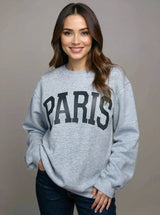 Woman wearing a light gray Basic Bae PARIS round-neck air scuba sweatshirt with long sleeves, styled with dark-wash jeans for a casual and comfortable look.