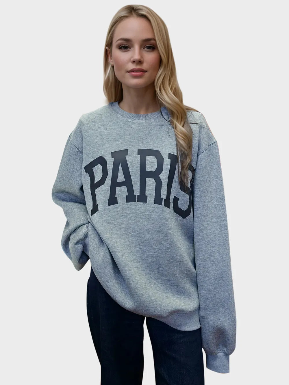 Woman wearing a light gray Basic Bae PARIS round-neck air scuba sweatshirt with long sleeves, styled with dark-wash jeans for a casual and comfortable look.