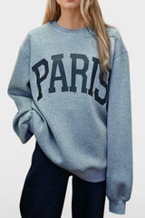 Woman wearing a light gray Basic Bae PARIS round-neck air scuba sweatshirt with long sleeves, styled with dark-wash jeans for a casual and comfortable look.
