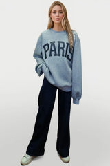 Woman wearing a light gray Basic Bae PARIS round-neck air scuba sweatshirt with long sleeves, styled with dark-wash jeans for a casual and comfortable look.