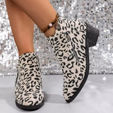Woman wearing beige leopard-print ankle boots with block heels and side zipper details.