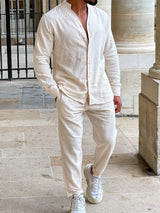 Men’s beige button up long sleeve top and matching pants two-piece set styled with white sneakers, available in sizes Small–2XL.