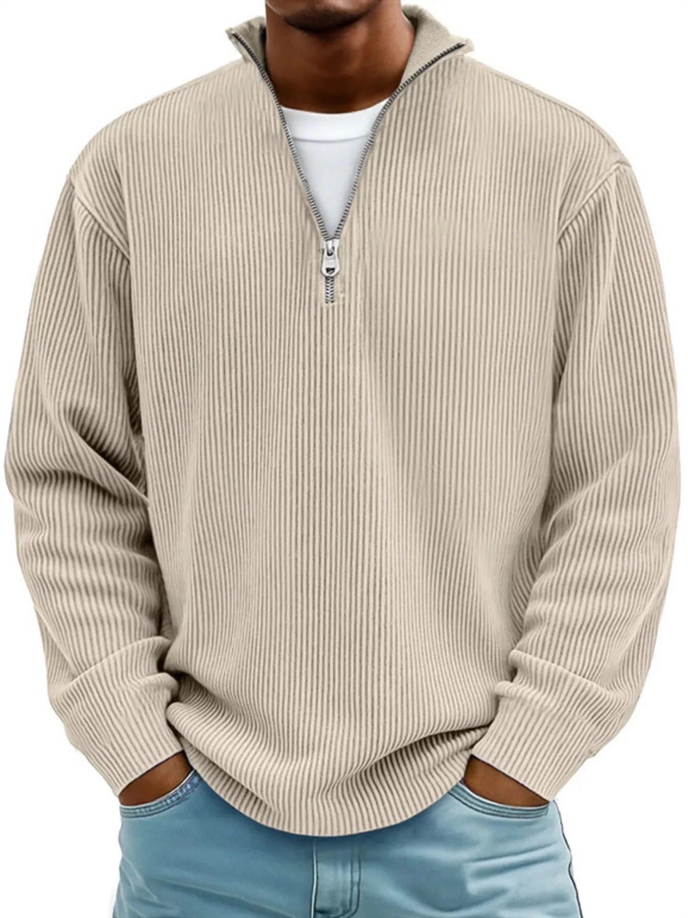 Man wearing a beige ribbed corduroy quarter zip pullover sweatshirt layered over a white shirt.