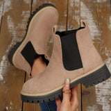 Beige suede round toe Chelsea ankle boots with black elastic side panels, mid-block heels and lug soles.