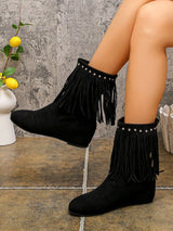 Black suede ankle boots featuring layered fringe and silver stud detailing around the ankle with a comfortable low heel.