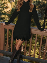 Woman wearing a black fringe turtleneck long sleeve sweater dress with brown knee-high boots, a cozy fall outfit from Chic Mystik Boutique.