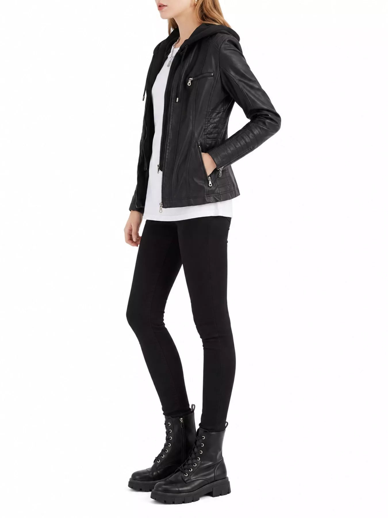 Woman wearing a black faux leather moto jacket with detachable drawstring hood, front zipper, seam detailing and zippered pockets, paired with black leggings.