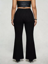 Model wearing black plus-size high-waisted flare pants styled with pointed-toe heels for an elegant and sophisticated look.