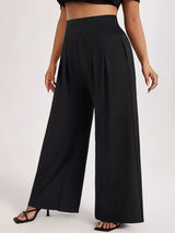 Model wearing black plus-size high-waisted wide-leg pants with a smocked waistband and side pockets.