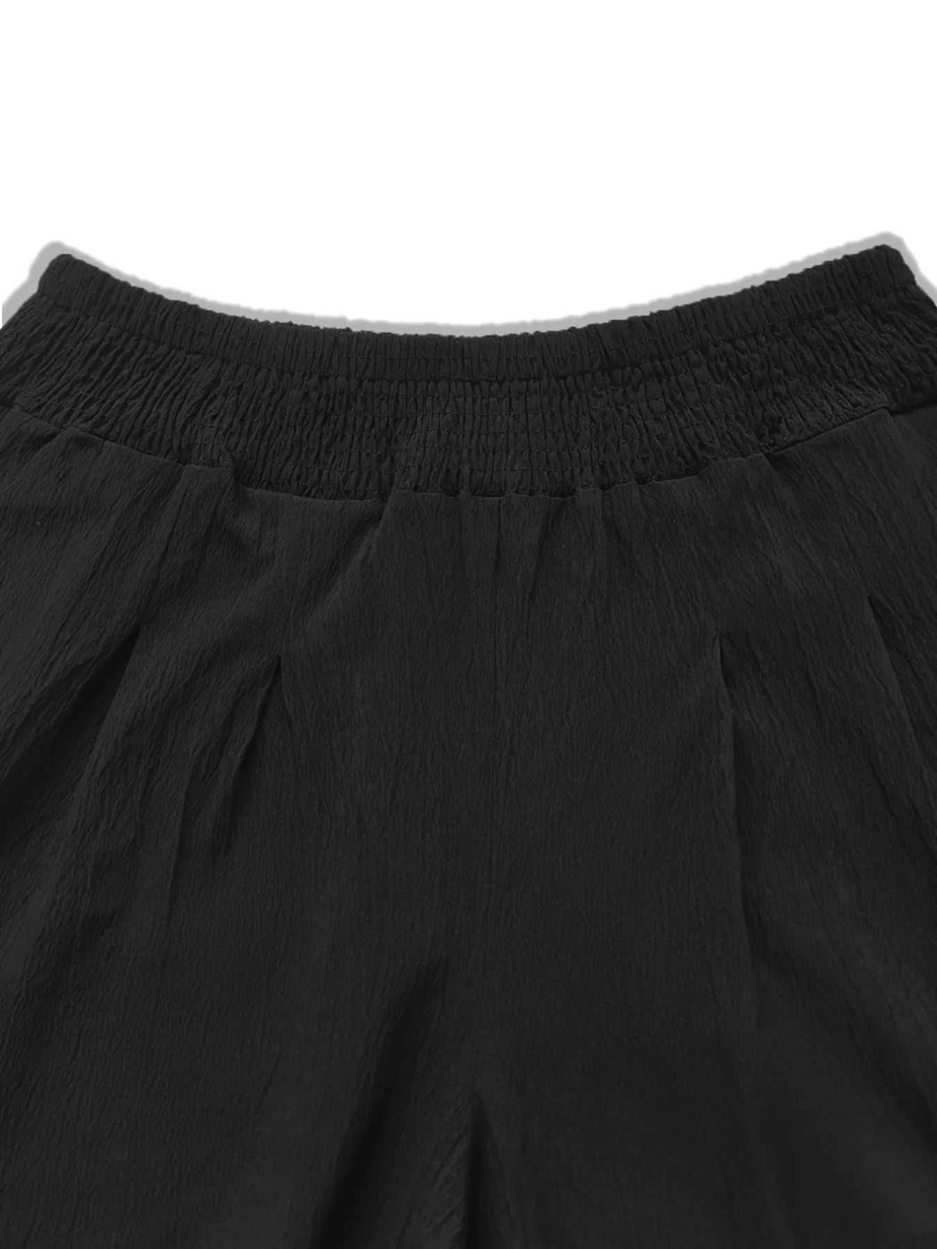 Model wearing black plus-size high-waisted wide-leg pants with a smocked waistband and side pockets.