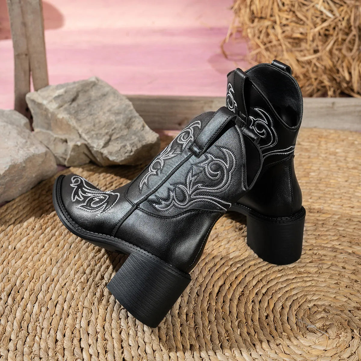 Black Western ankle boots featuring white embroidered details, a pointed toe, and a mid-height block heel.