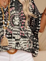Black printed V-neck top with half sleeves and a relaxed boho-inspired fit paired with white shorts.