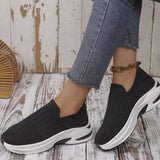 Black women’s round toe mesh slip-on sneakers with a lightweight knit upper and sporty white and black rubber sole.