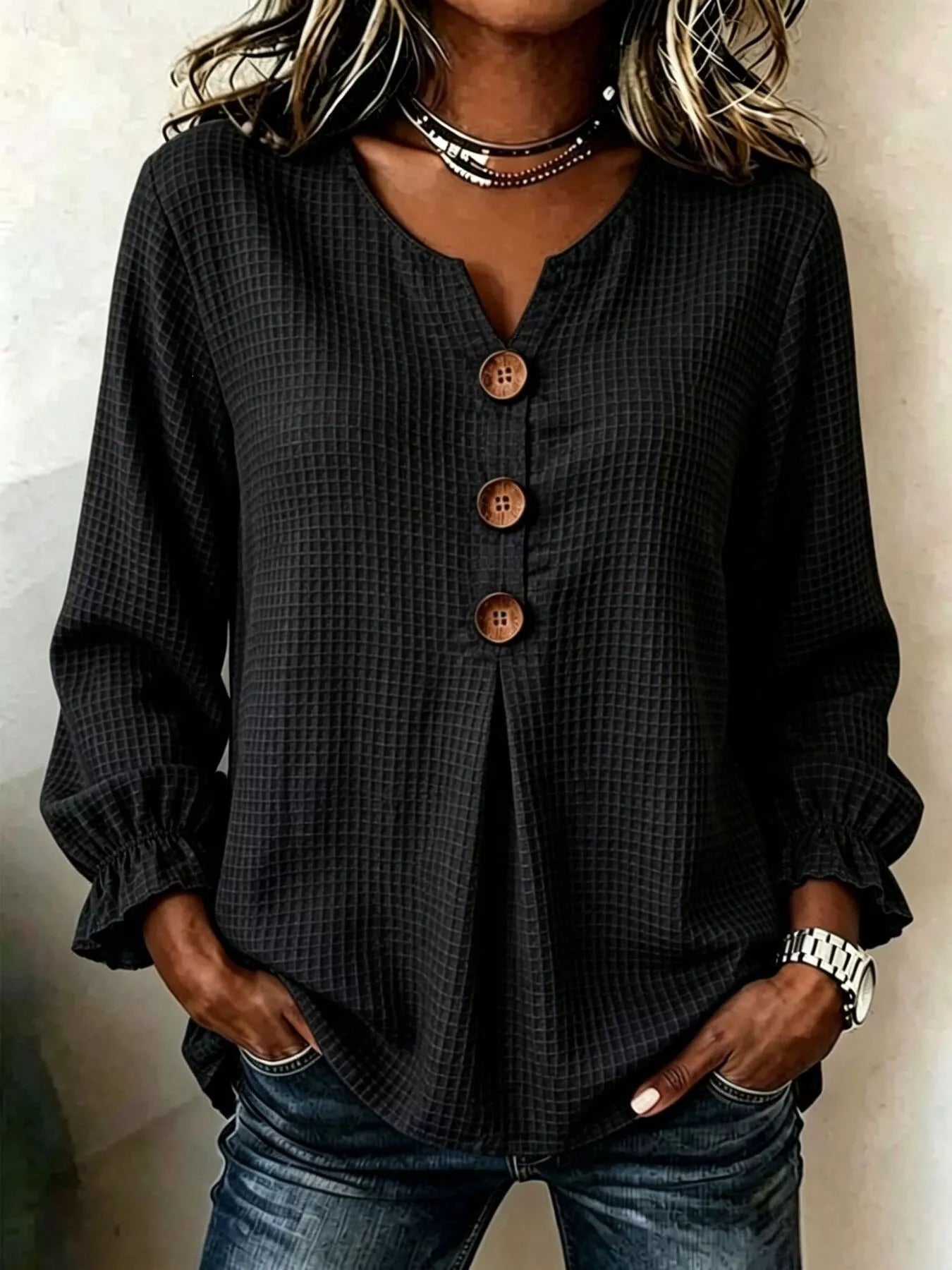 Women’s black waffle knit flounce sleeve top with button front detail and ruffled cuffs.