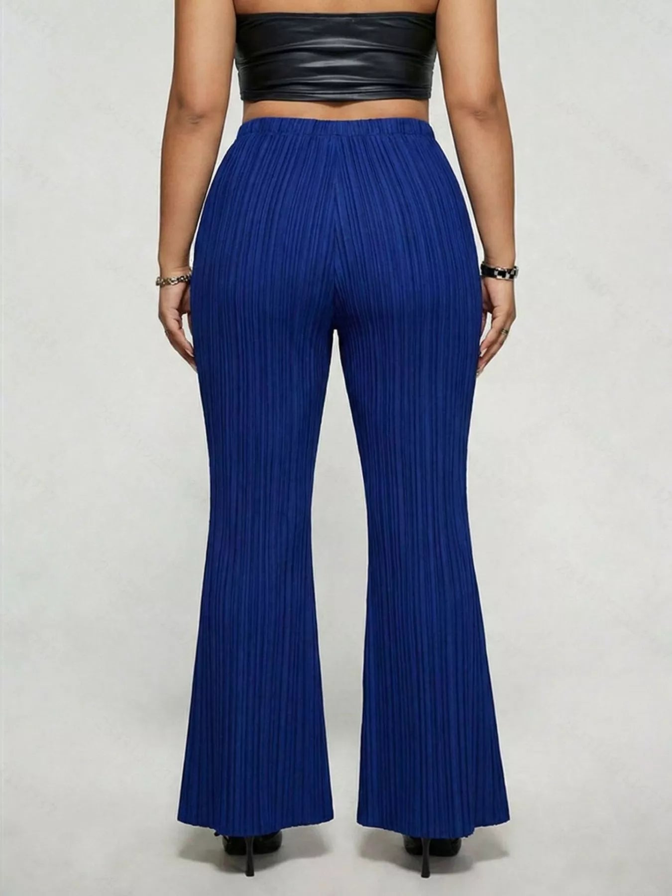 Model wearing blue plus-size high-waisted flare pants styled with pointed-toe heels for an elegant and sophisticated look.