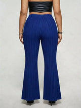 Model wearing blue plus-size high-waisted flare pants styled with pointed-toe heels for an elegant and sophisticated look.