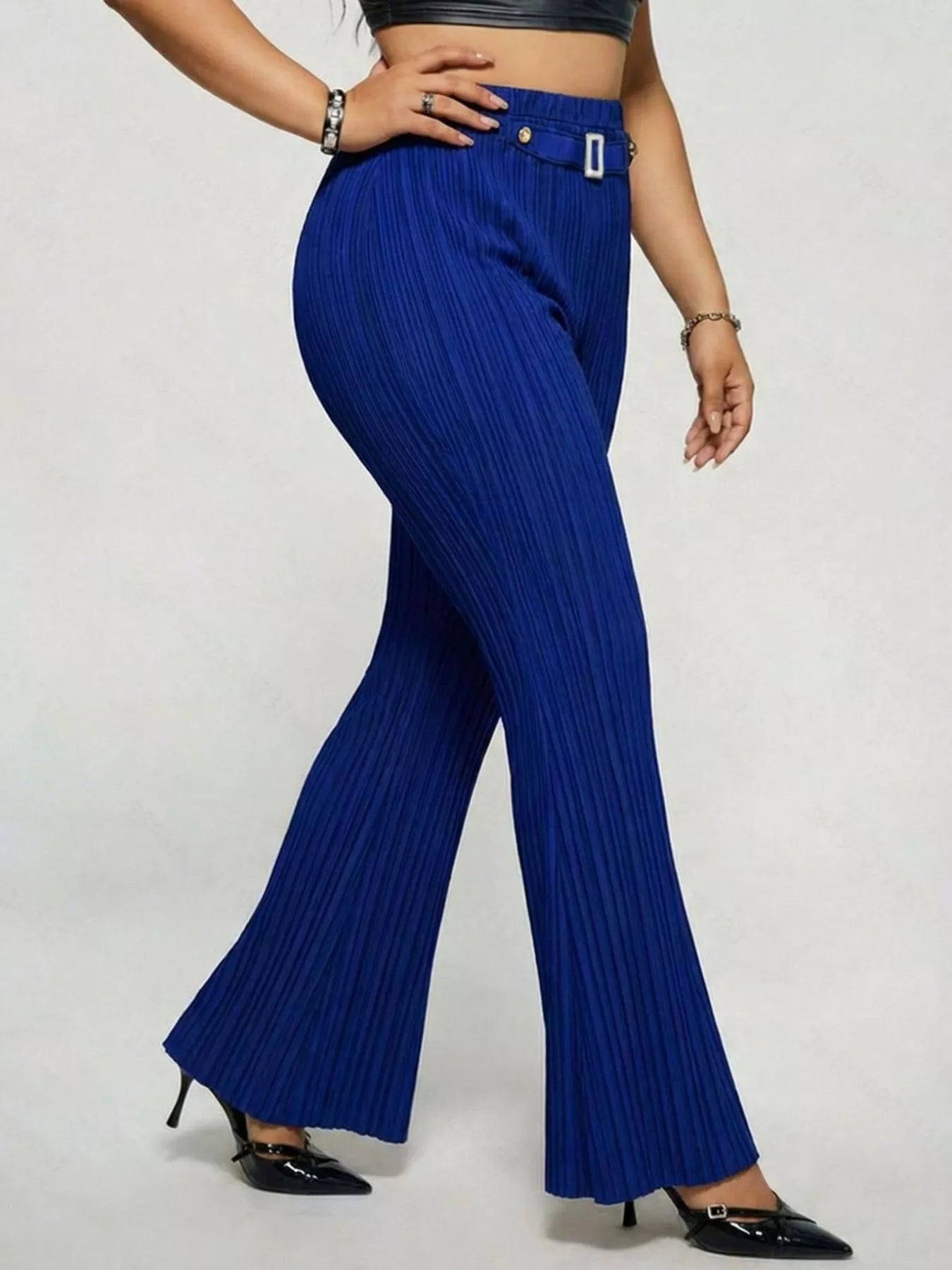 Model wearing blue plus-size high-waisted flare pants styled with pointed-toe heels for an elegant and sophisticated look.