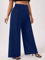 Model wearing blue plus-size high-waisted-leg pants with a smocked waistband and side pockets.