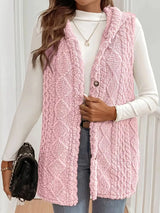 Woman wearing a blush pink hooded sherpa vest coat over a white long-sleeve top with blue jeans for a cozy fall and winter outfit.