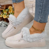 Light gray sneakers with fluffy white laces worn by a person on a light wooden floor.