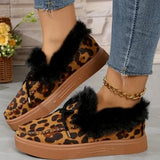 Leopard print slippers with fur trim worn by a person in jeans.