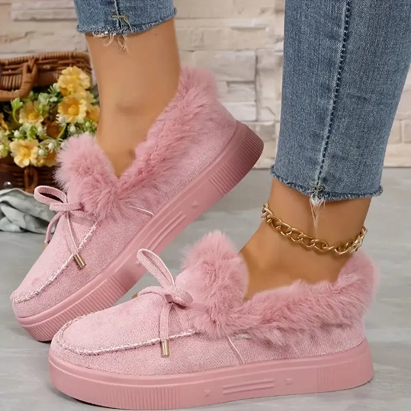 Pink fuzzy sneakers worn with denim jeans on a light background