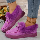 Purple fuzzy shoes worn with denim jeans on a light background