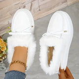 White slip-on shoes with fluffy fur trim worn by a person indoors.