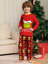 Boy wearing red Grinch-themed Christmas pajama sets with green character graphics and coordinating red plaid holiday pants.
