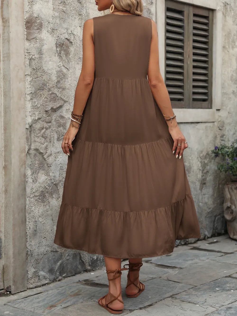 Woman wearing the Ivy Lane decorative button sleeveless dress with a notched neckline and a flattering silhouette.