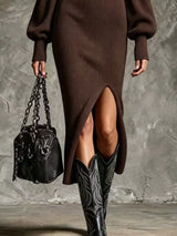 Woman wearing a brown ribbed knit quarter-zip sweater dress with long lantern sleeves, front slit and black embroidered western boots.