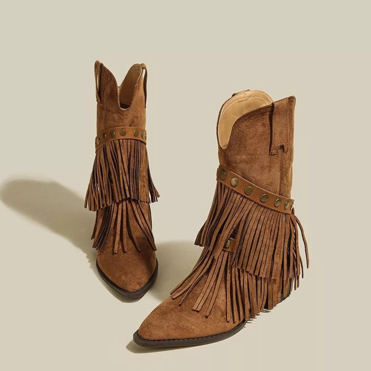 Brown suede Western boots with pointed toes, layered fringe, studded straps and low heels.