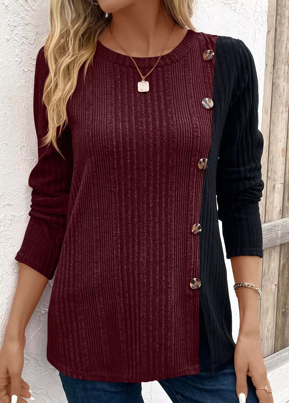 Women’s burgundy and black color block ribbed knit long sleeve top with decorative side buttons and slit detail, available in sizes Small–2XL.