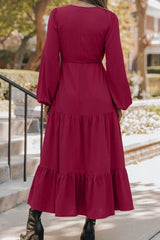 Woman wearing burgundy tiered midi dress with drawstring waist, long sleeves and black ankle boots